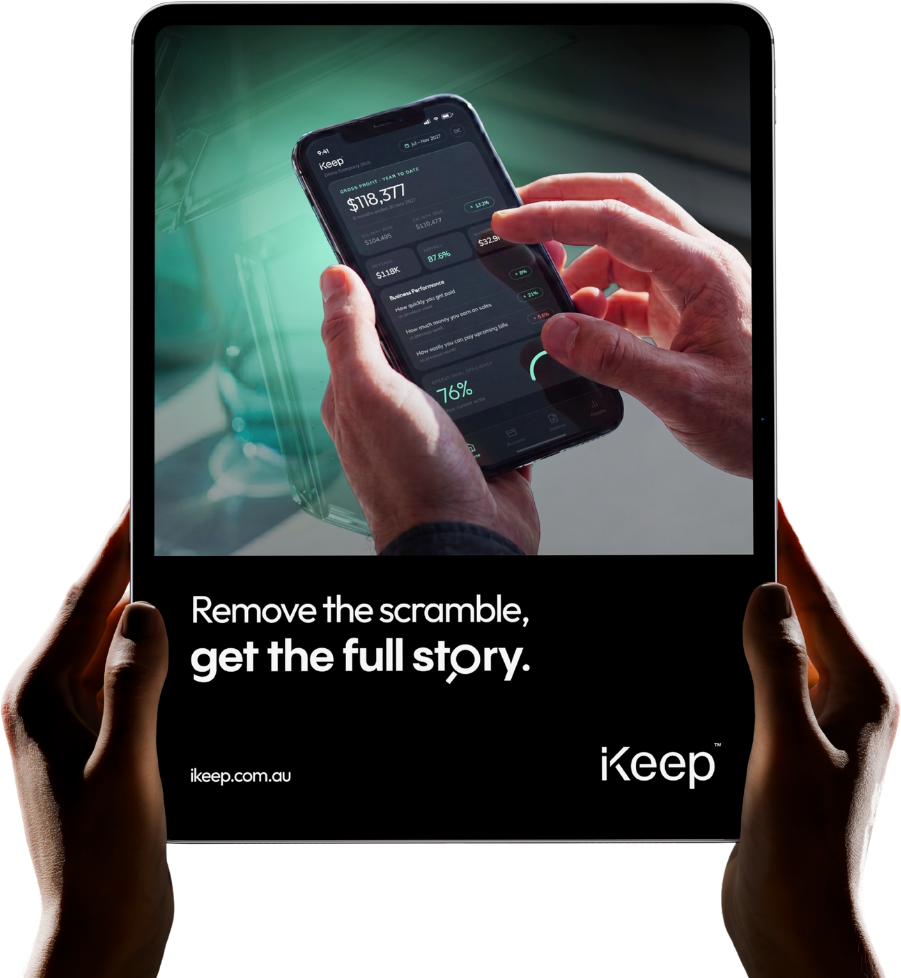 A business owner holding an iPad showing the iKeep campaign — Remove the scramble, get the full story